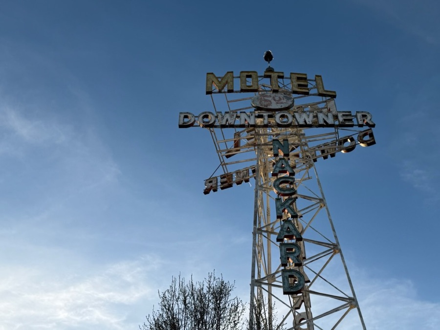 The Motel Downtowner neon letters lit at dusk